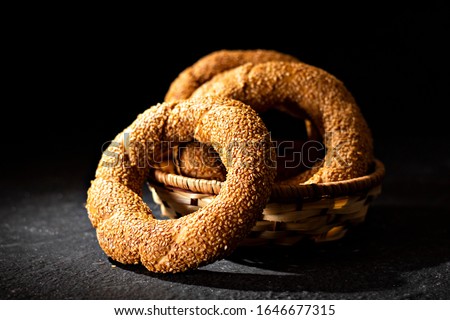 A close-up of Turkish Bagel / Simit withe sesame seeds, on black background. - Image. - Image
 Royalty-Free Stock Photo #1646677315