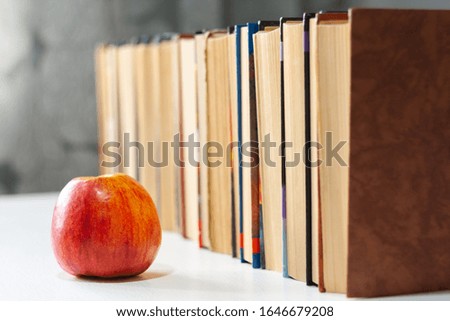 stack of hardback books on white table with red apple. Books stacking. Back to school concept. Copy Space. Education learning background