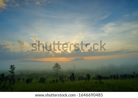 Sunrise behind mountain in the morning with magnificent mist landscape in winter season Thailand 