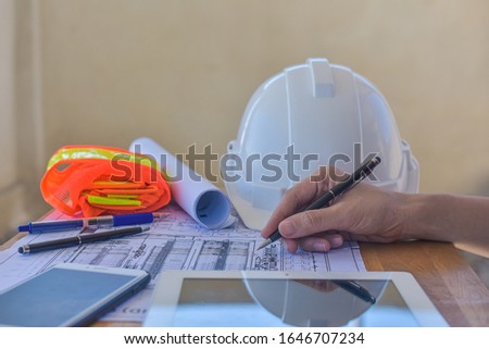 Close up hand writing on paperwork blueprint inspection plan construction architecture project design 