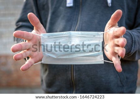 medical mask in hands close-up. disposable medical three-layer mask with elastic.