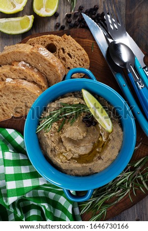 Cream souffle 'Babaganush' eggplant in a blue plate on a dark background. Next to a green-white napkin Royalty-Free Stock Photo #1646730166