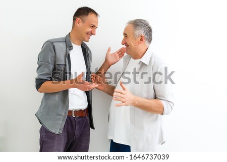 Cheerful father and son hugging and posing together isolated on white background