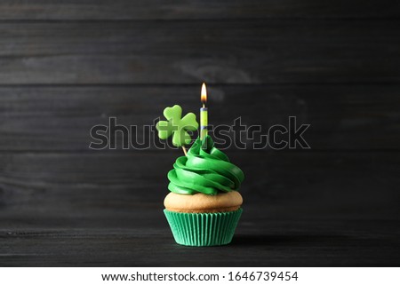 Decorated cupcake on black wooden table. St. Patrick's Day celebration