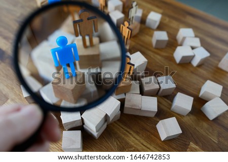 Businessman hold in hand magnifying glass. Look at silhouette of blue toy man. Lgbtq people search career concept. Royalty-Free Stock Photo #1646742853