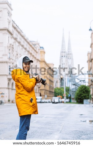 photographer tourist taking picture of city street with votive church on background