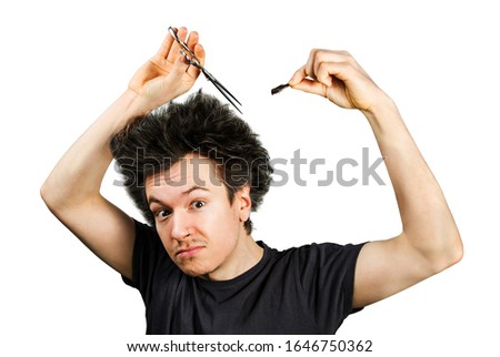 long hair man shears hair and looks in camera, on a white isolated background.