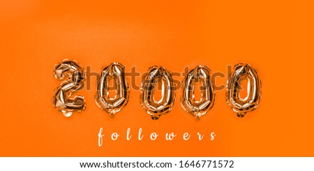 Air gold balloons in the form of numbers 20000 on orange background. Followers concept