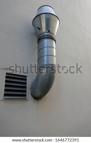 Extractor. Ventilation. Aluminum  pipe of an extractor hood on a white outer wall
 