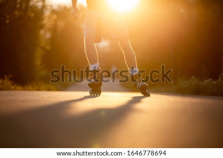 Man roller skating on the cycle path during lovely summer sunset, sport concept