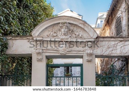 Paris, an ancient door, with a head carved on the lintel, beautiful house in Montmartre
