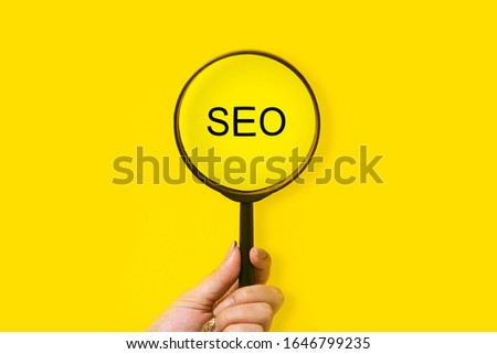 magnifier in hand and inscription SEO, seo search concept