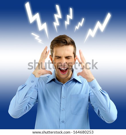 Angry young man on blue background