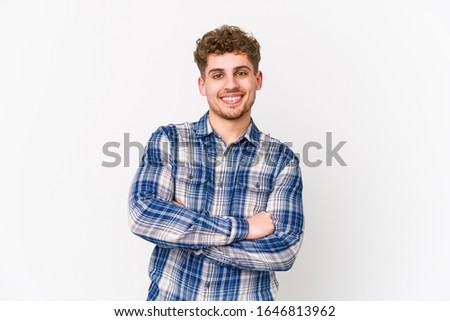 Young blond curly hair caucasian man isolated who feels confident, crossing arms with determination.