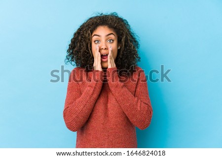 Young african american curly hair woman shouting excited to front.