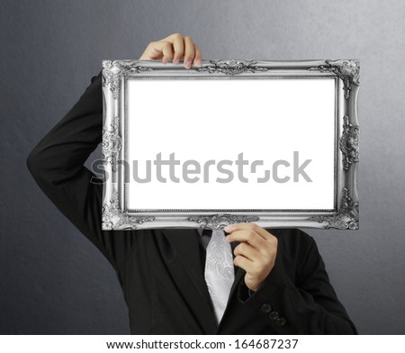 businessman looking through an empty picture frame 