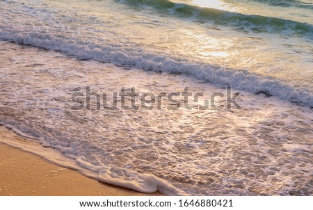 Close up photo of parallel waves washing up on shore