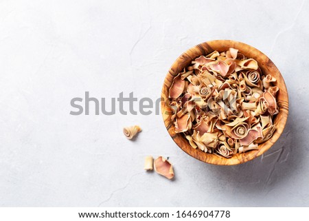 Dried lemon grass in a wooden bowl on a light grey table. Top view. Copy space.