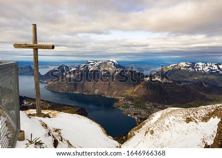Pictures of snow-capped mountains with a view of the lake and the mountain front and a wooden cross
