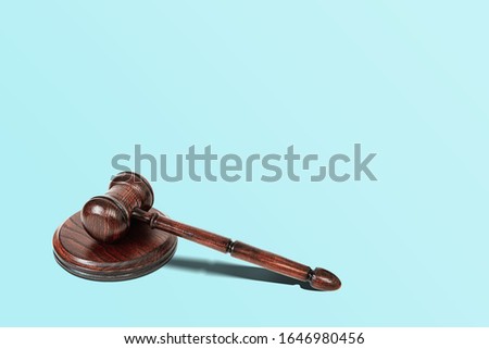 Wooden Judge's gavel on a blue pastel background. The concept of justice and dealing with court cases. Citizens' problems in courts, honesty. The work of courts and lawyers.