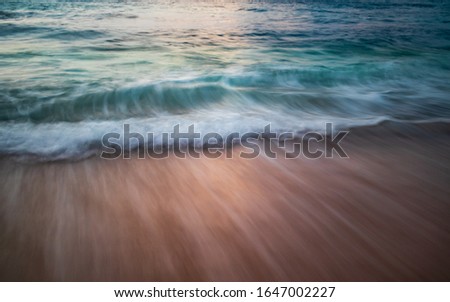 Scenic seascape. Silky milky foam waves at sandy beach. Sunset time. Waterscape for background. Slow shutter speed. Soft focus. Motion blur.  Bingin beach, Bali, Indonesia