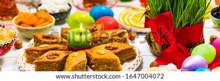 Novruz Ramadan in Azerbaijan. Colored Eggs, Wheat Springs for Easter and Traditional Sweets. Panoramic image. Selective focus.
