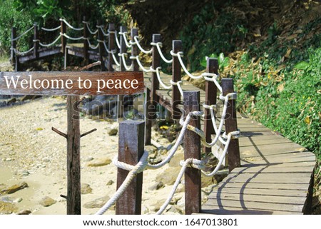 Wooden sign written Welcome to peace on the wooden bridge background