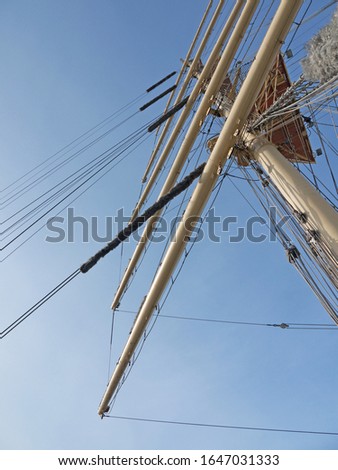 Looking up to the tall Vintage sailing ship mast and sailyards, clear blue sky