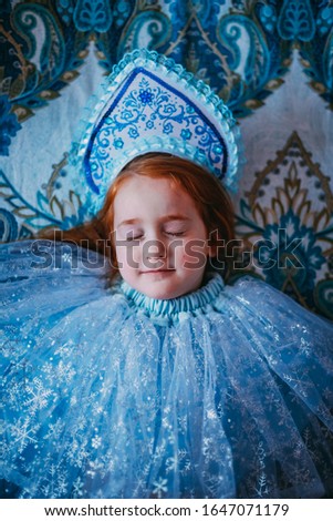 Red girl on blue background in snow queen suit