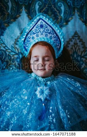 Red girl on blue background in snow queen suit