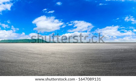 Empty race track and green hill with beautiful sky clouds.