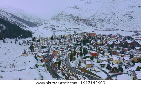Flight over the famous village of Andermatt in Switzerland in winter - aerial photography