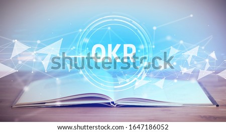 Open book with OKR abbreviation, modern technology concept
