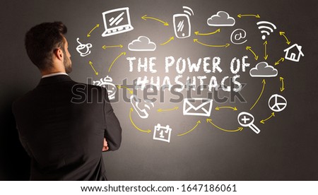businessman drawing social media icons with THE POWER OF #HASHTAGS inscription, new media concept