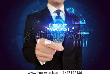 Businessman holding lightbulb with PROPERTY MANAGEMENT inscription, Business idea concept