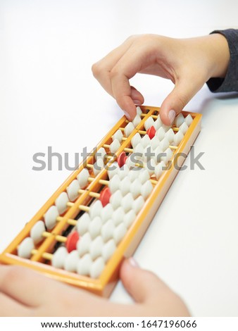 Classes in mental arithmetic, hands and abacus soroban on white background. closeup