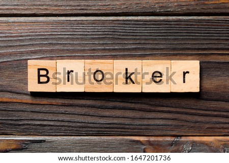 broker word written on wood block. broker text on wooden table for your desing, concept.