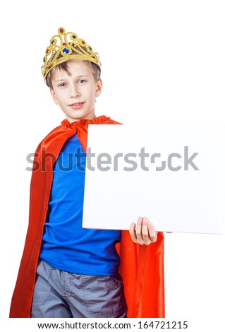 Beautiful cheerful child dressed as king with a crown holds a rectangular white board with space for text 