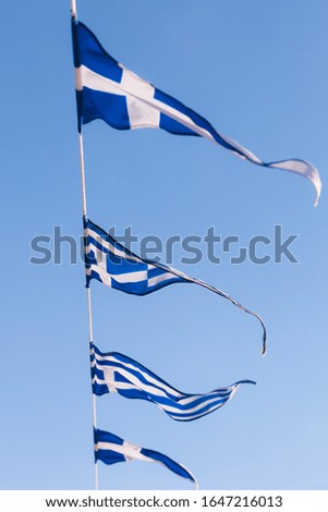 Greek flags waving outdoor on strings during summer weather. Greece European country national landmark