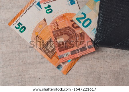 Euro banknotes in leather wallet on light background.