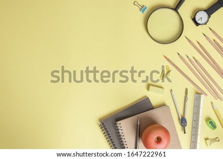 Top view school supplies on yellow background with copy space.