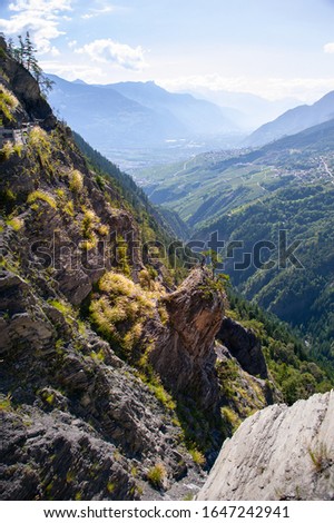 Alpine landscape, Saviese, Switzerland. Green forested slopes with rocky outcrop.
