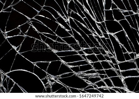 Broken black glass with white cracks. Damaged screen