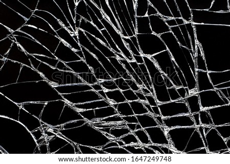 Broken black glass with white cracks. Damaged screen