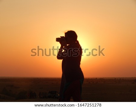 Female photographer silhouette at sunset in Rajasthan