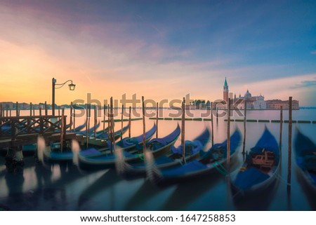 Venice lagoon at sunrise, San Giorgio Maggiore church and gondolas. Italy, Europe. Long exposure photography.