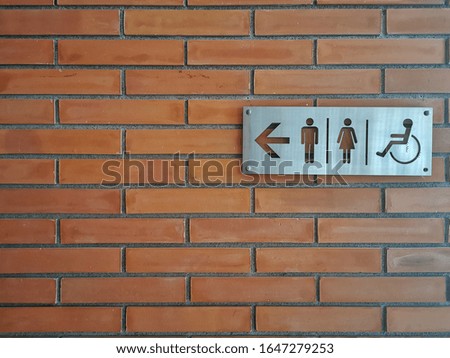 steel restroom sign on brick wall as a background