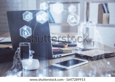 Computer on desktop in office with technology theme hologram. Multi exposure. Tech concept.