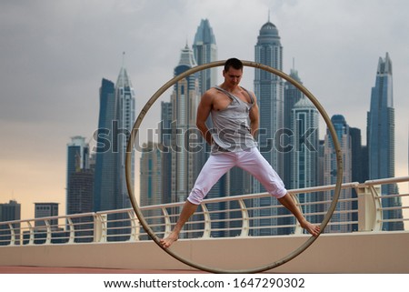 Cyr Wheel artist with cityscape background of Dubai during sunset
