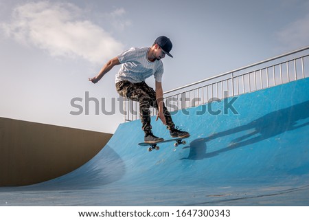 young skateboarder flies with his board on the ramp of a skate park